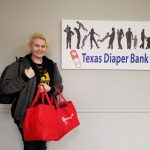 Photo of Amanda in front of Texas Diaper Bank sign